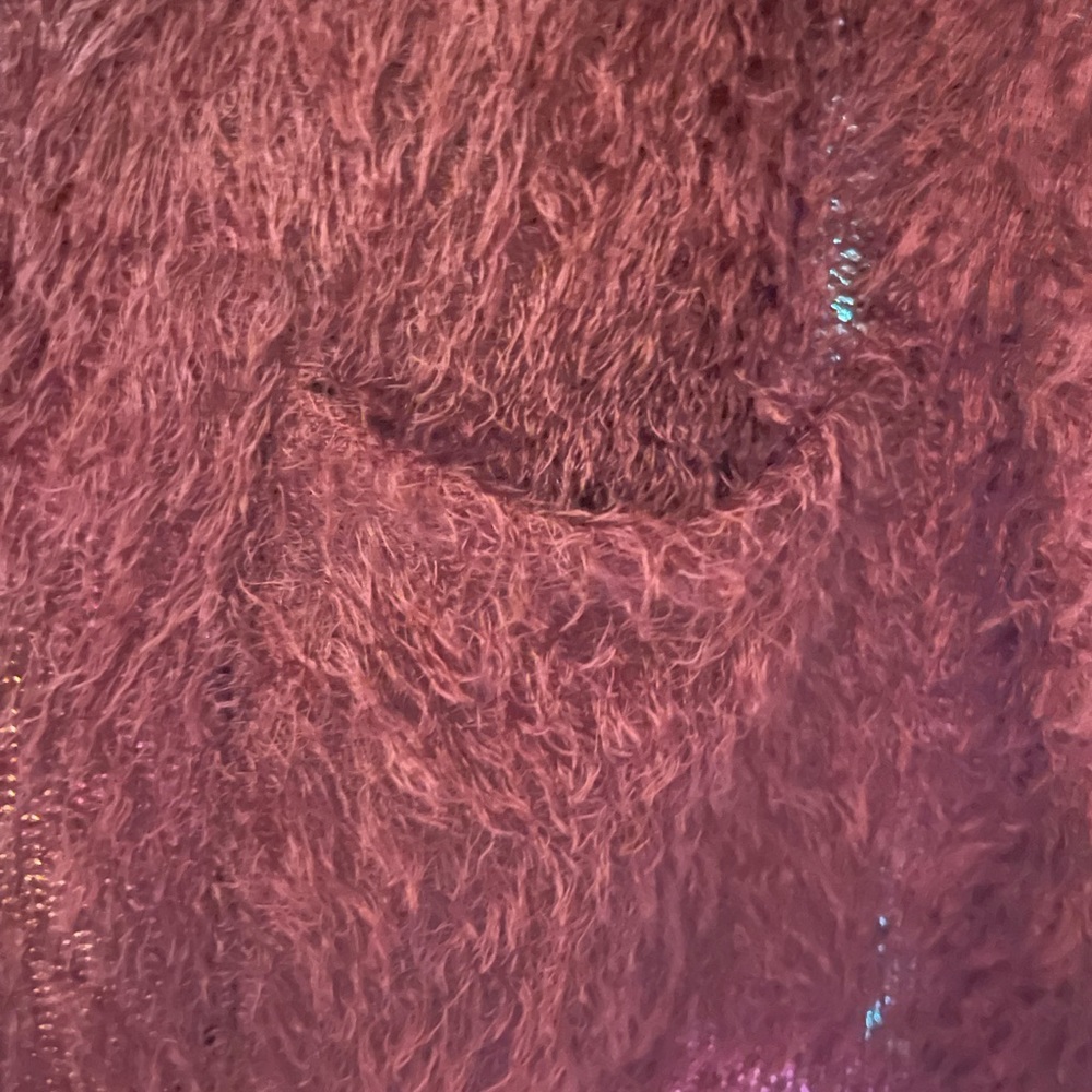 Burgundy jacket. Fuzzy material but not itchy, pockets, hits at hips.